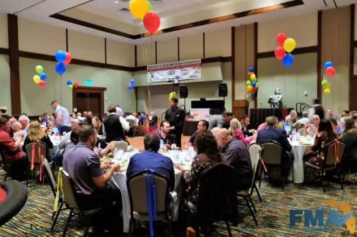 Photo of people eating and watching a speech