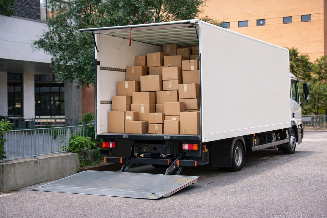 Truck using a liftgate to unload palletized freight from a box truck at a non dock delivery location